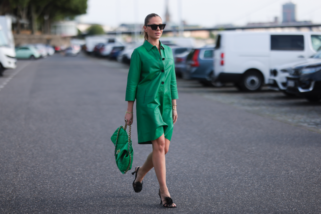 Sieviete zaļā ādas kleitā
