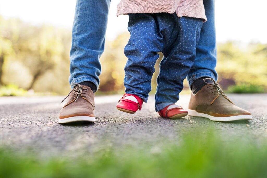 Tētis māca staigāt mazuli sarkanos, plakanos apavos.