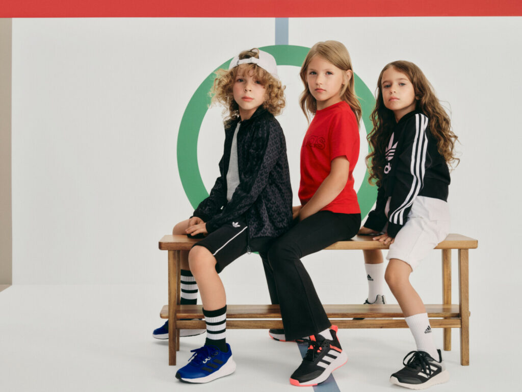 Trīs bērni sporta apģērba un sporta apavos un sporta tērpos