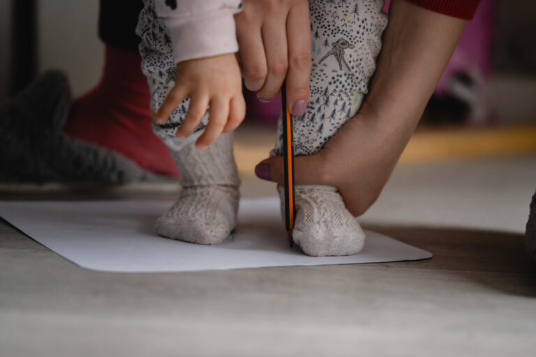 Bērna pēdu apzīmēšana uz papīra lapas